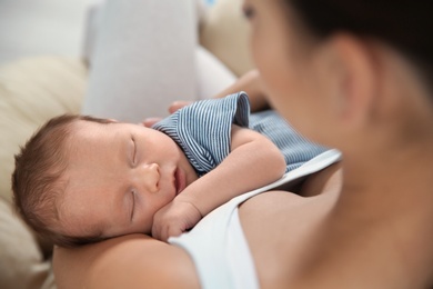 Photo of Young woman holding her newborn baby, closeup