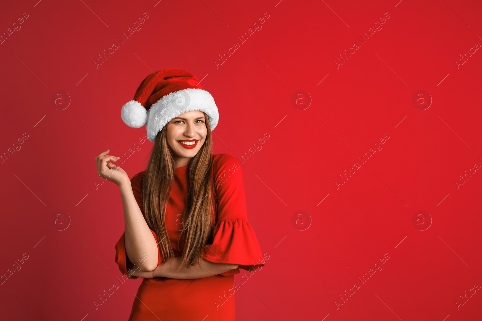 Photo of Young beautiful woman in Santa hat on color background. Christmas celebration