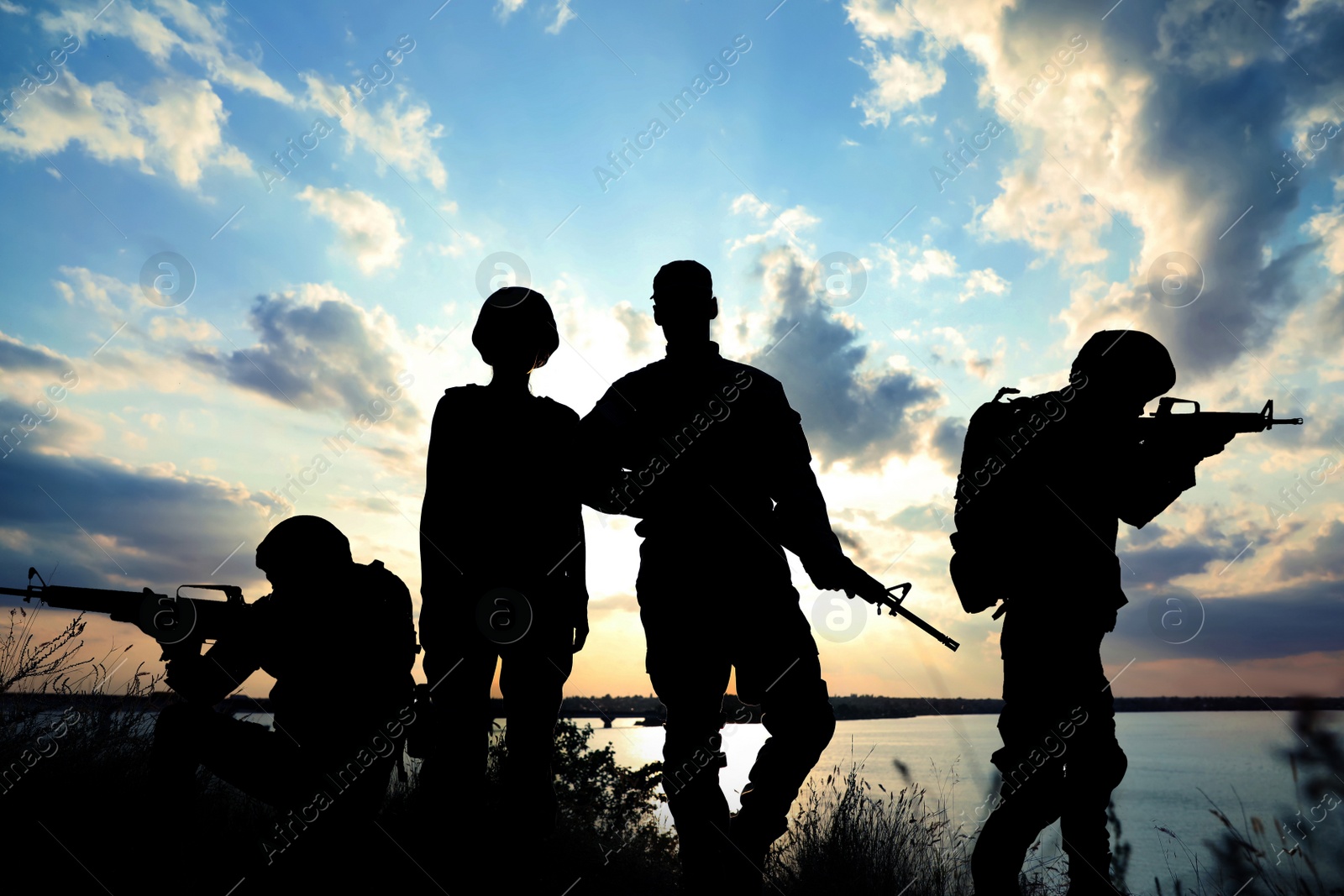 Image of Silhouettes of soldiers with assault rifles patrolling outdoors. Military service