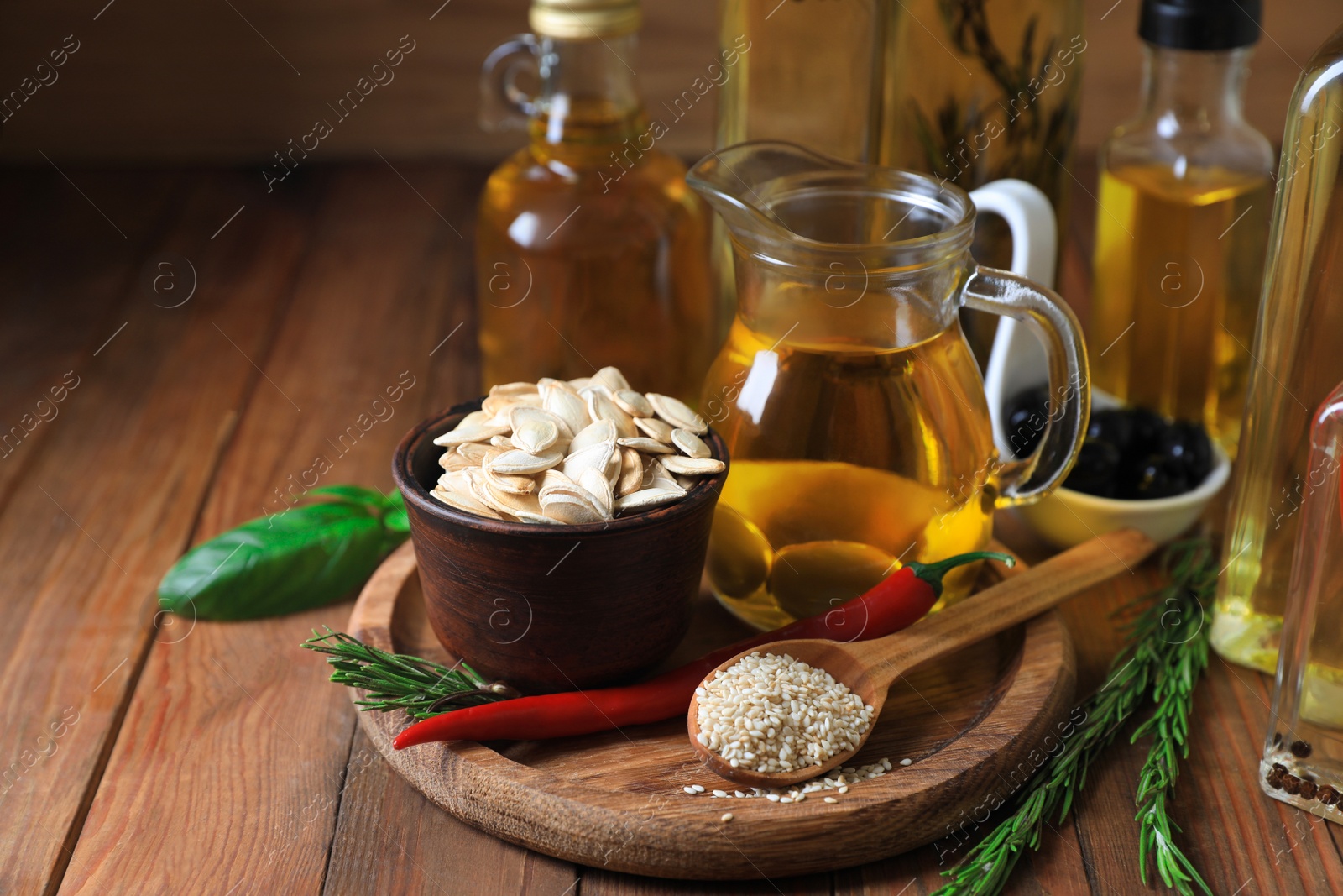 Photo of Different cooking oils and ingredients on wooden table