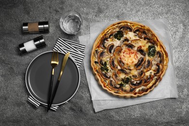 Photo of Delicious quiche with mushrooms served on dark grey table, flat lay