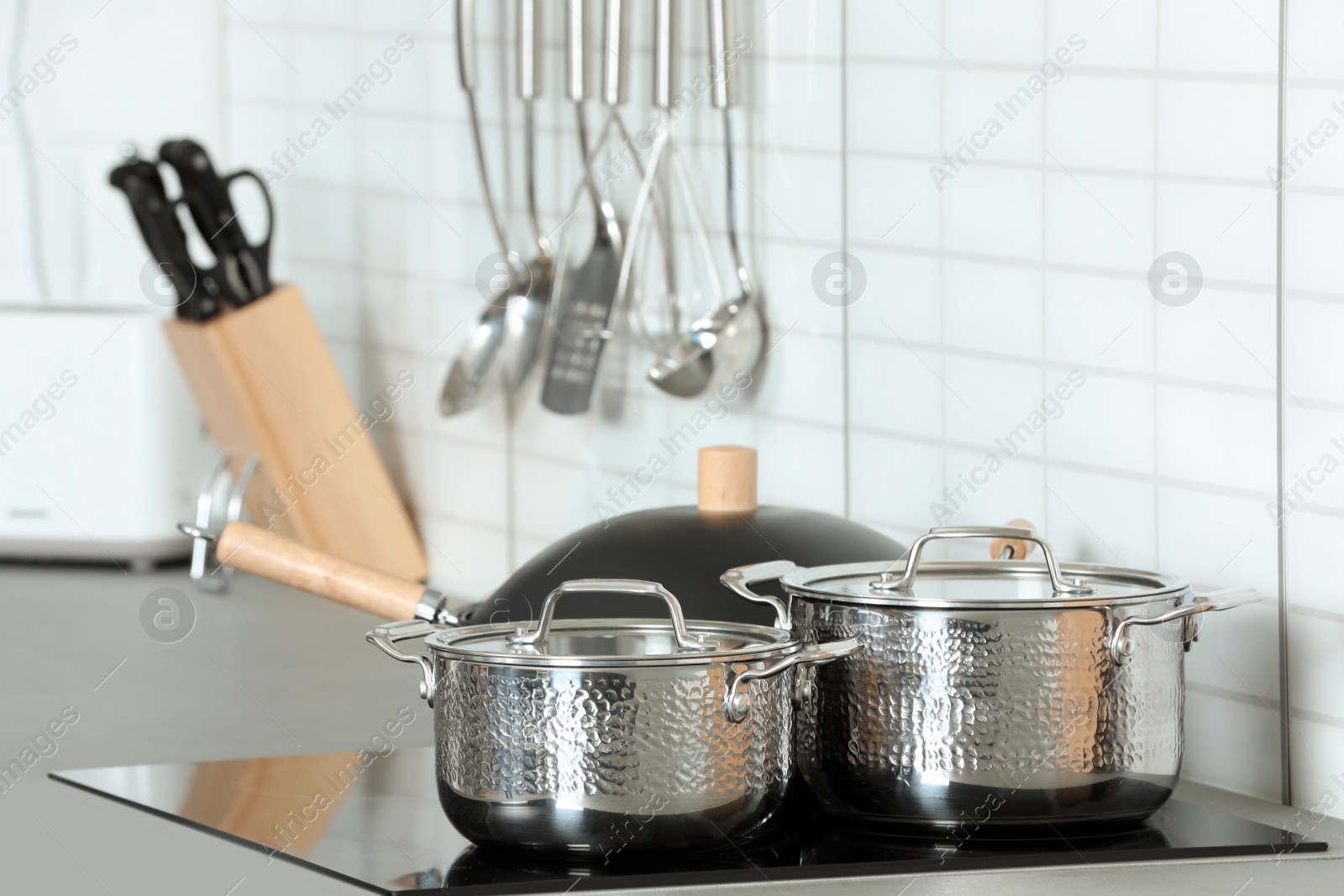 Photo of Set of clean cookware on stove in kitchen. Space for text