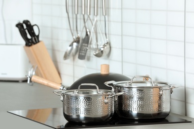 Set of clean cookware on stove in kitchen. Space for text