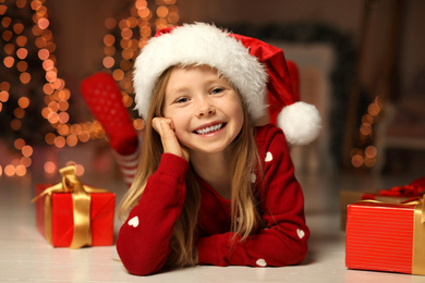 Cute little child with Christmas gifts at home