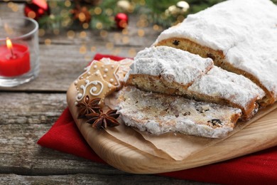 Traditional Christmas Stollen with icing sugar on wooden table