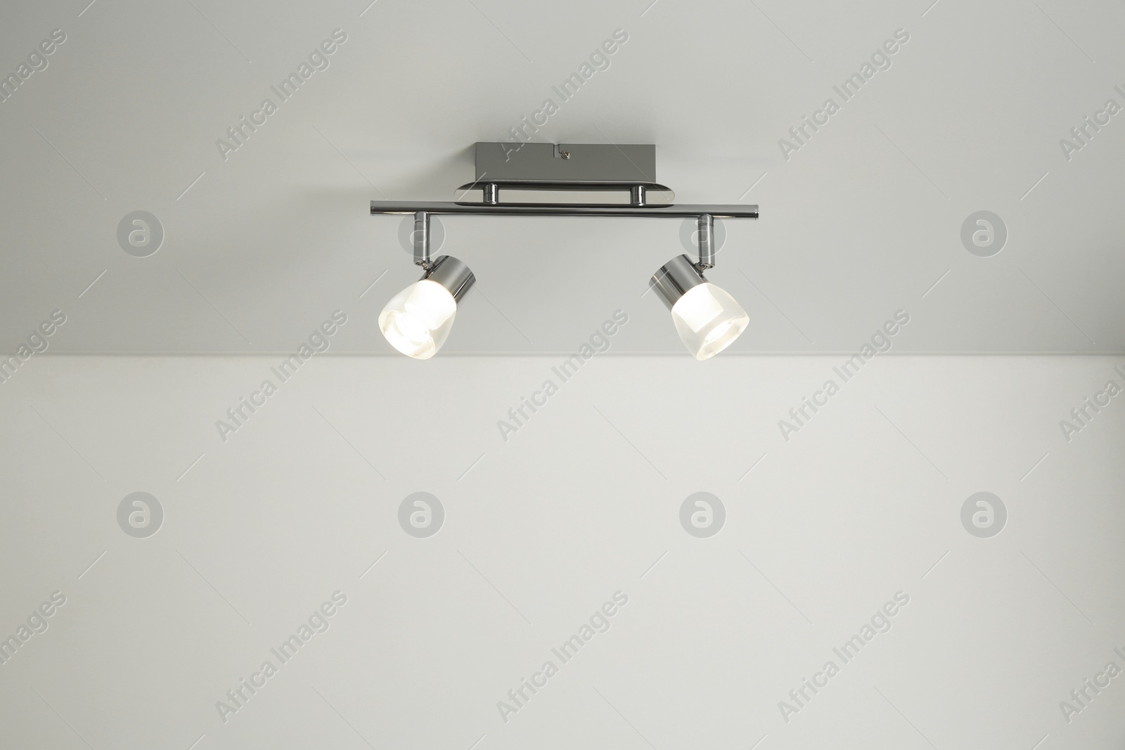 Photo of Stylish light fixture on ceiling indoors, low angle view