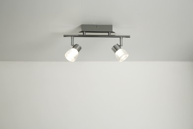 Stylish light fixture on ceiling indoors, low angle view