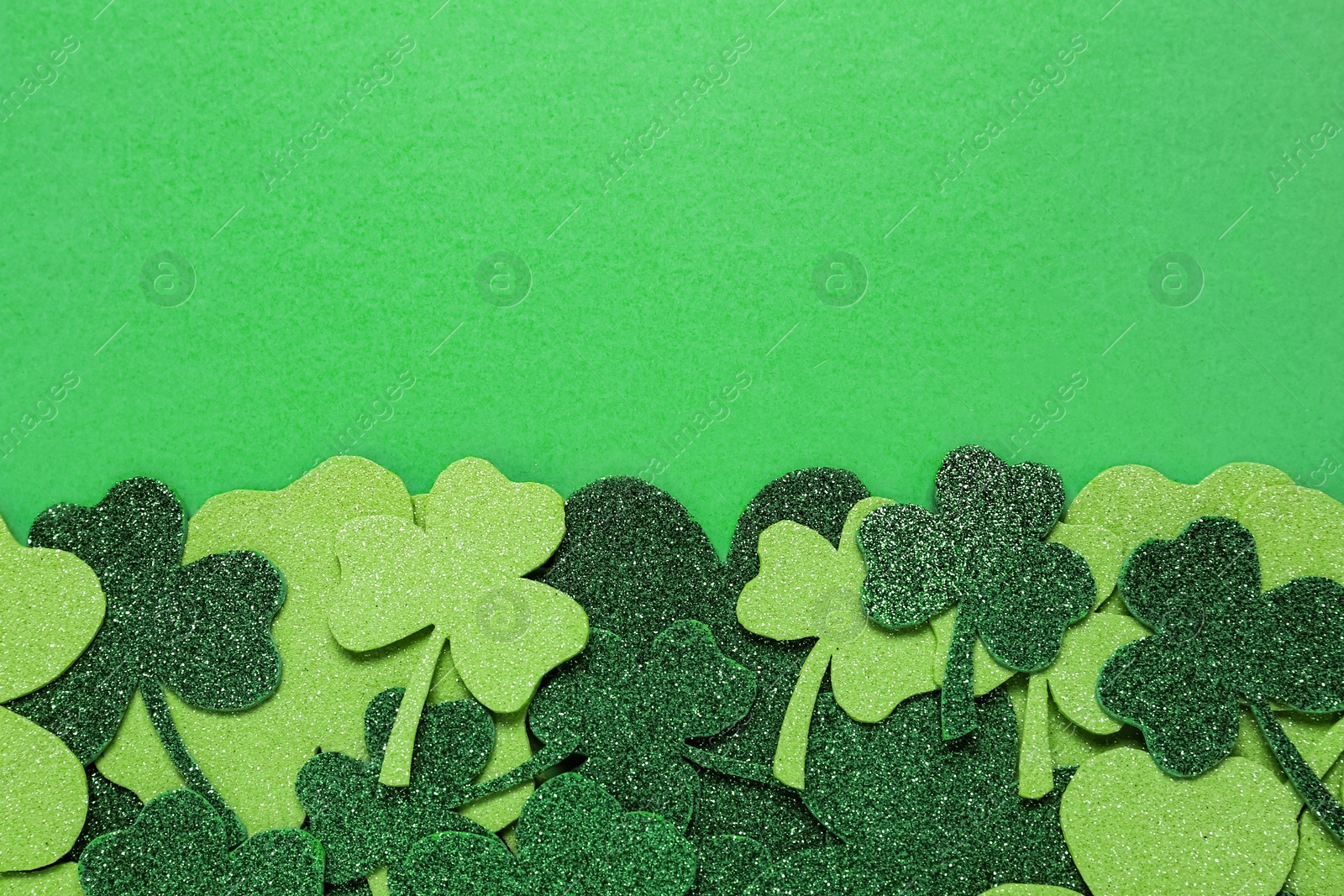 Photo of Flat lay composition with clover leaves on light green background, space for text. St. Patrick's Day celebration