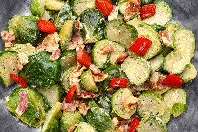 Delicious cooked Brussels sprouts with bacon in pan, closeup