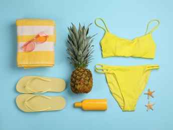 Photo of Flat lay composition with beach accessories on light blue background