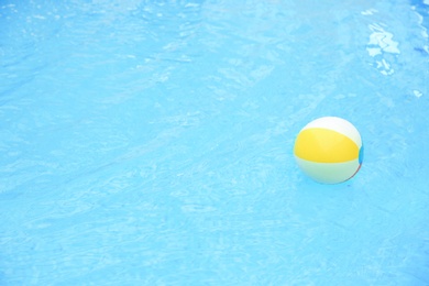 Photo of Colorful inflatable ball floating on water in swimming pool