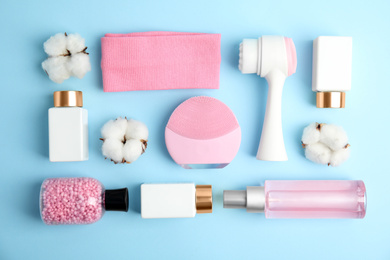 Photo of Flat lay composition with face cleansing brushes on light blue background. Cosmetic tools