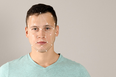 Image of Facial recognition system. Young man with biometric identification scanning grid on beige background, space for text