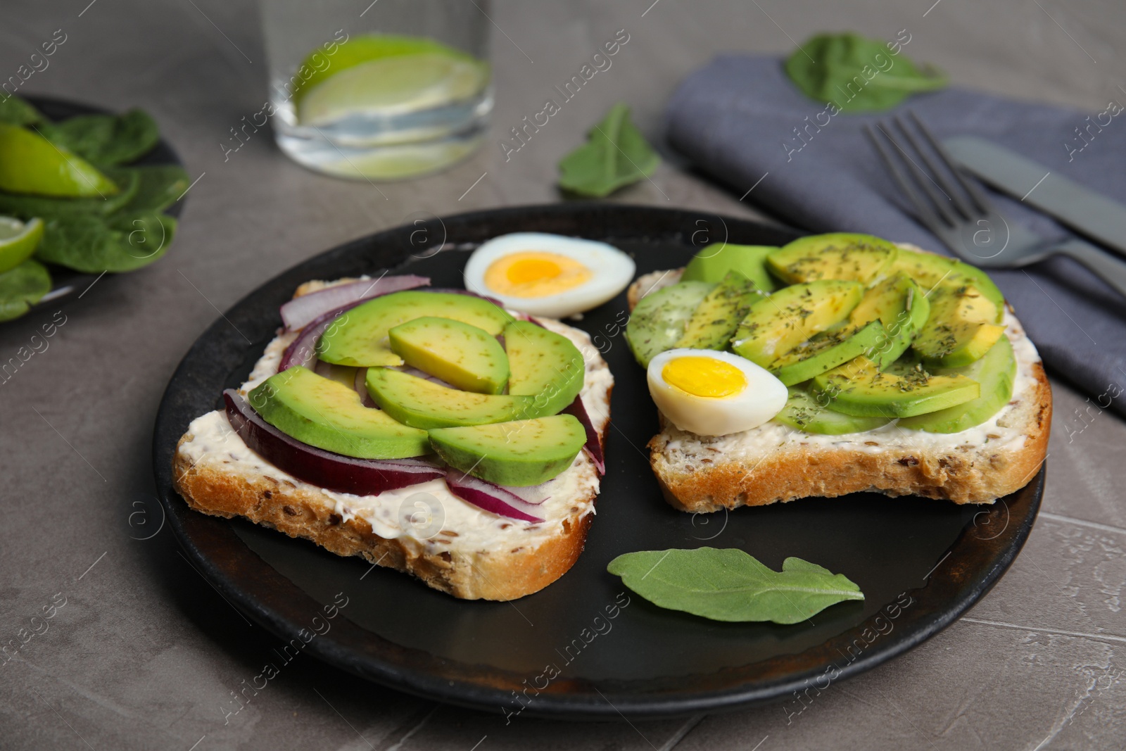 Photo of Tasty avocado toasts served on grey table