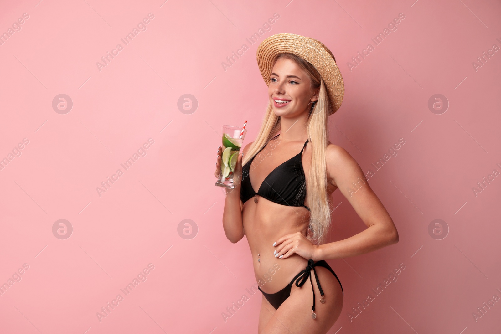 Photo of Pretty young woman wearing stylish bikini with cocktail on pink background