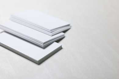 Photo of Blank business cards on light grey textured table, closeup. Mockup for design