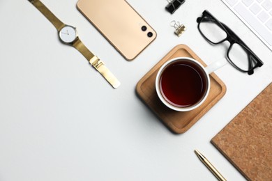 Photo of Flat lay composition with ceramic mug of aromatic tea and glasses on white background. Space for text