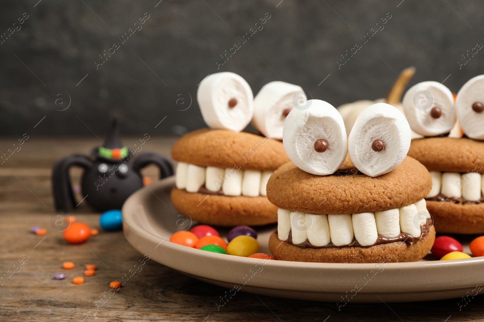 Photo of Delicious Halloween themed desserts on wooden table, closeup