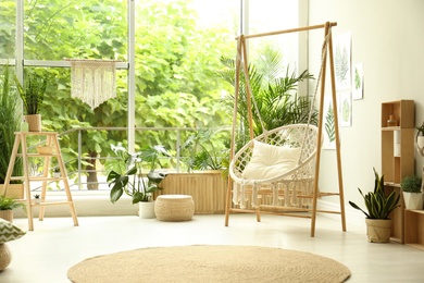 Photo of Comfortable hammock chair in stylish room. Home interior