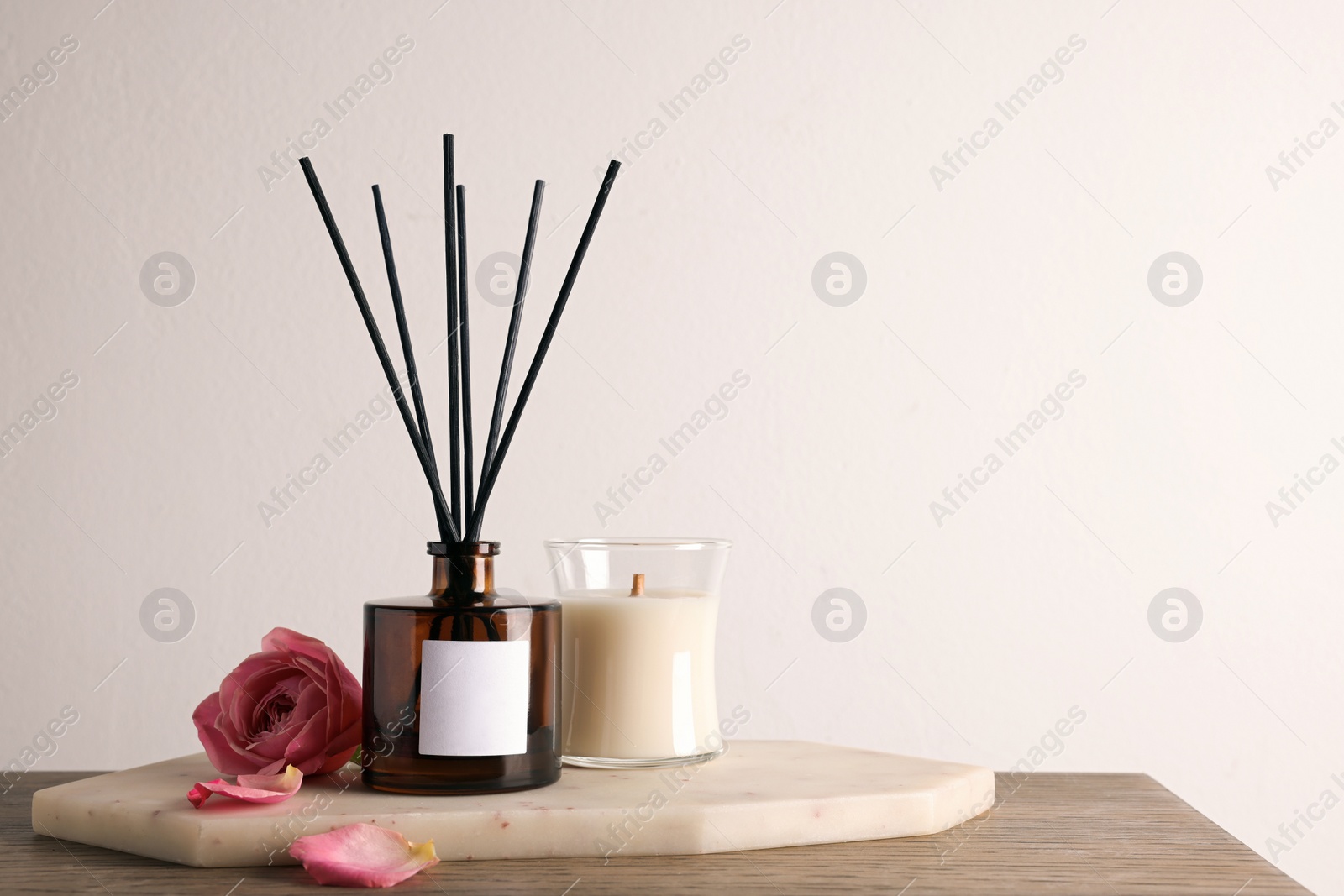 Photo of Composition with aromatic reed air freshener on wooden table, space for text