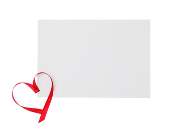 Photo of Blank card and heart made of red ribbon on white background, top view. Valentine's Day celebration