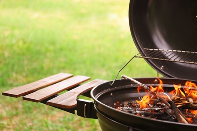 Photo of Modern barbecue grill with fire flames outdoors