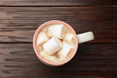 Photo of Tasty hot chocolate with marshmallows on wooden table, top view