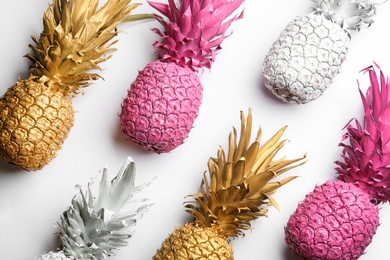 Painted pineapples on white background, top view. Creative concept