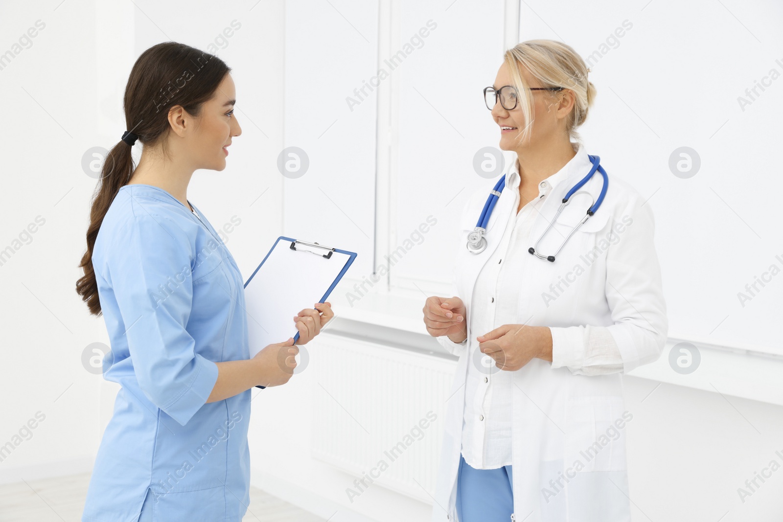 Photo of Medical doctors in uniforms having discussion indoors