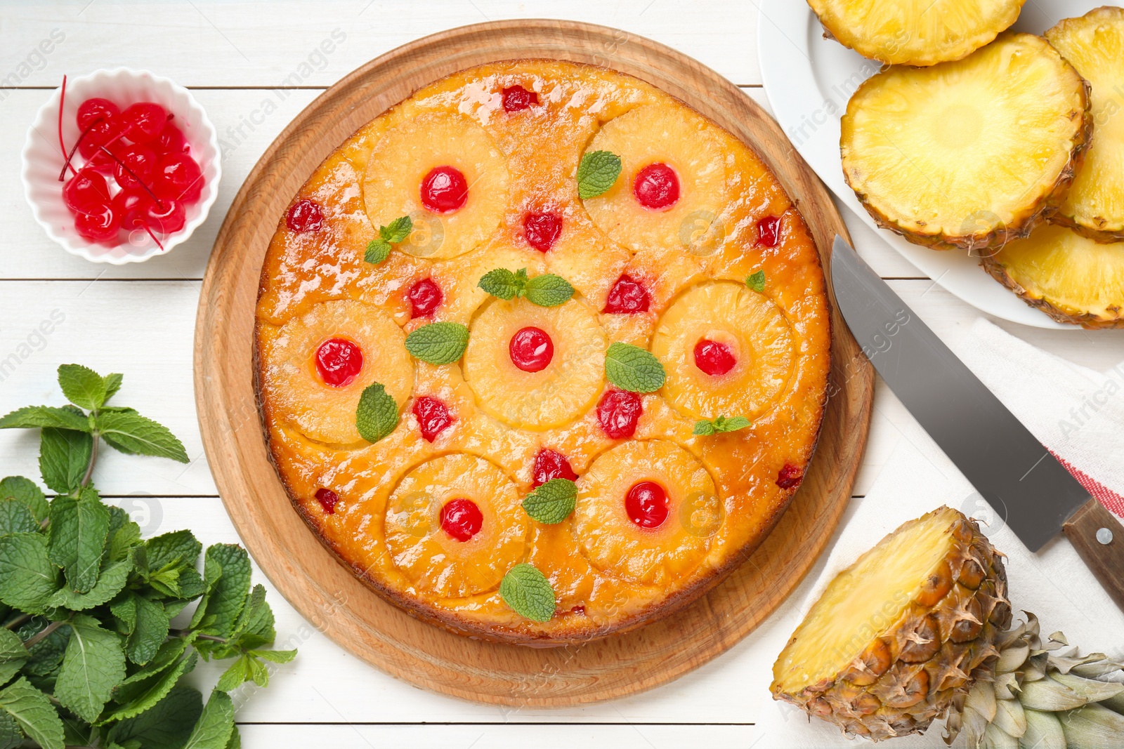 Photo of Delicious pineapple pie with cherry and mint on white wooden table, flat lay