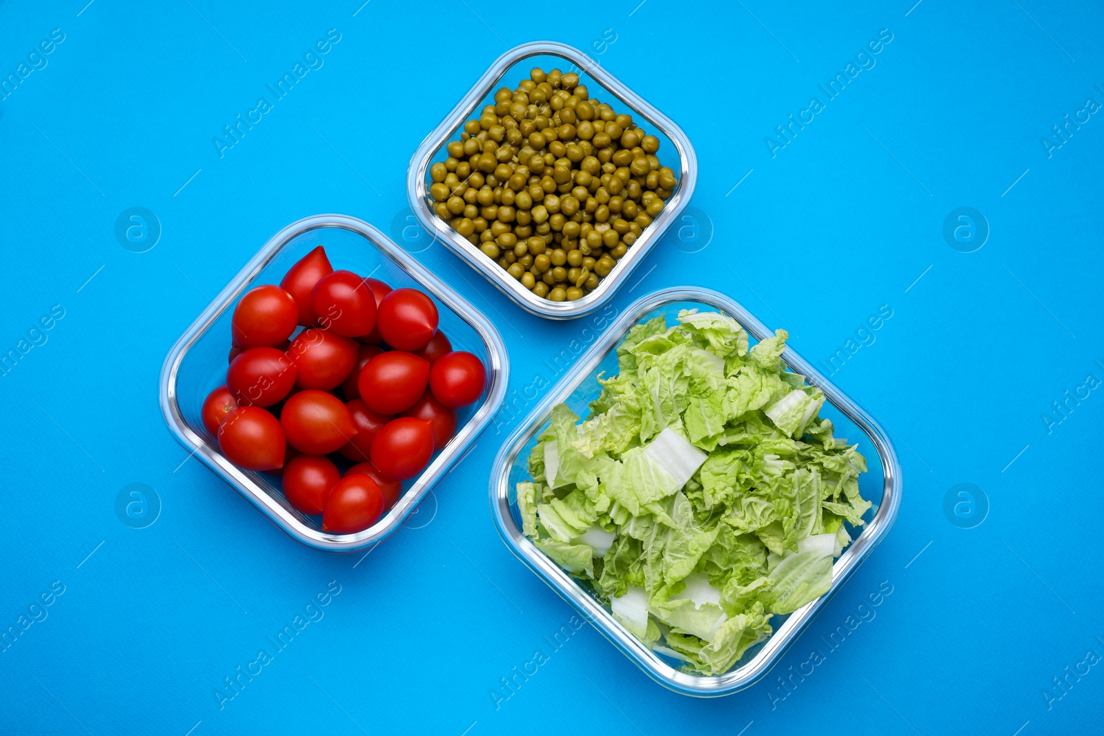 Photo of Glass containers with different fresh products on light blue background, flat lay