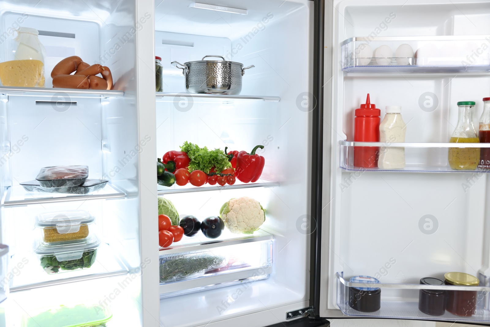 Photo of Modern open refrigerator full of different products