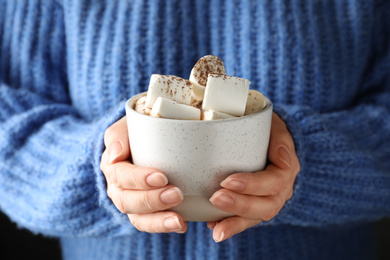 Photo of Woman holding cup of delicious hot cocoa with marshmallows, closeup. Winter drink