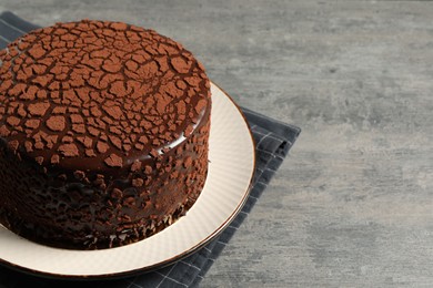 Photo of Delicious chocolate truffle cake on grey textured table, space for text