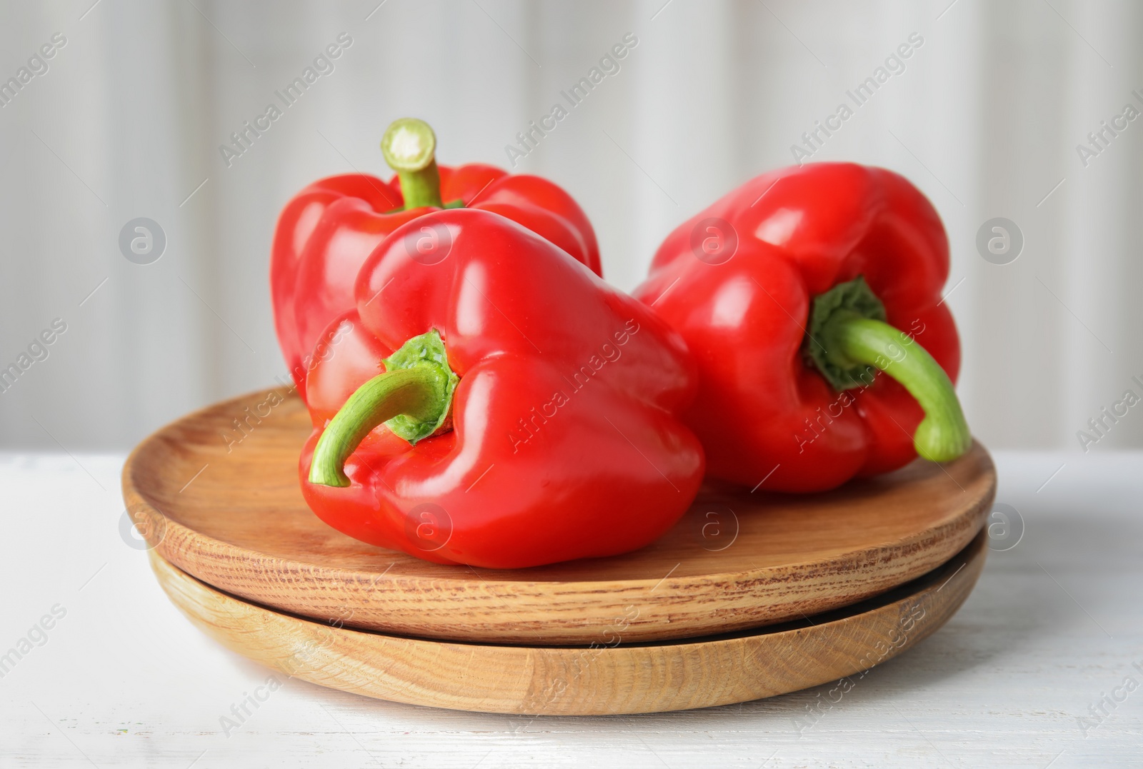 Photo of Plates with ripe paprika peppers on table