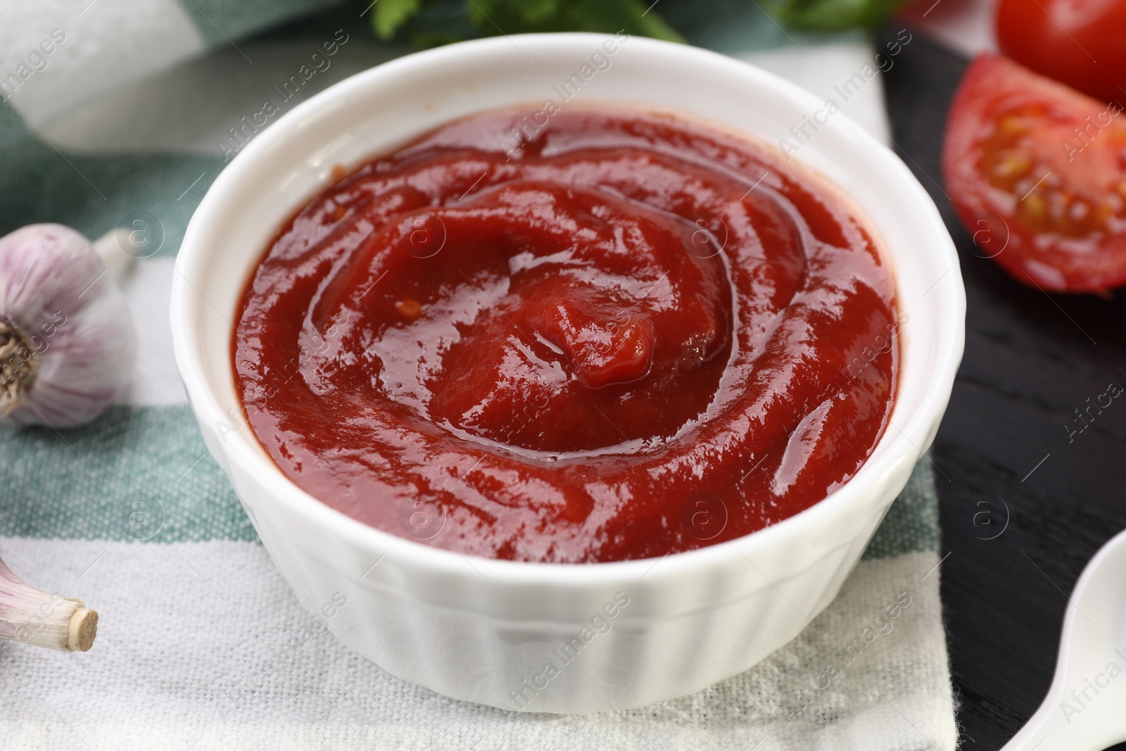 Photo of Organic ketchup in bowl on table, closeup. Tomato sauce