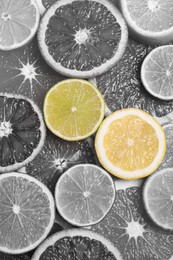 Image of Fresh juicy citrus fruits as background, top view. Black and white tone with selective color effect