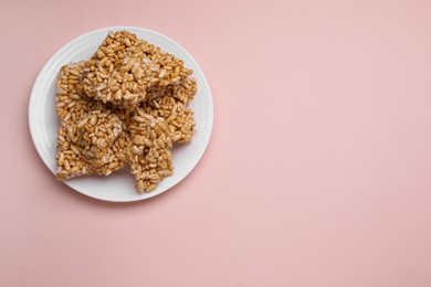 Puffed rice bars (kozinaki) on pale pink background, top view. Space for text