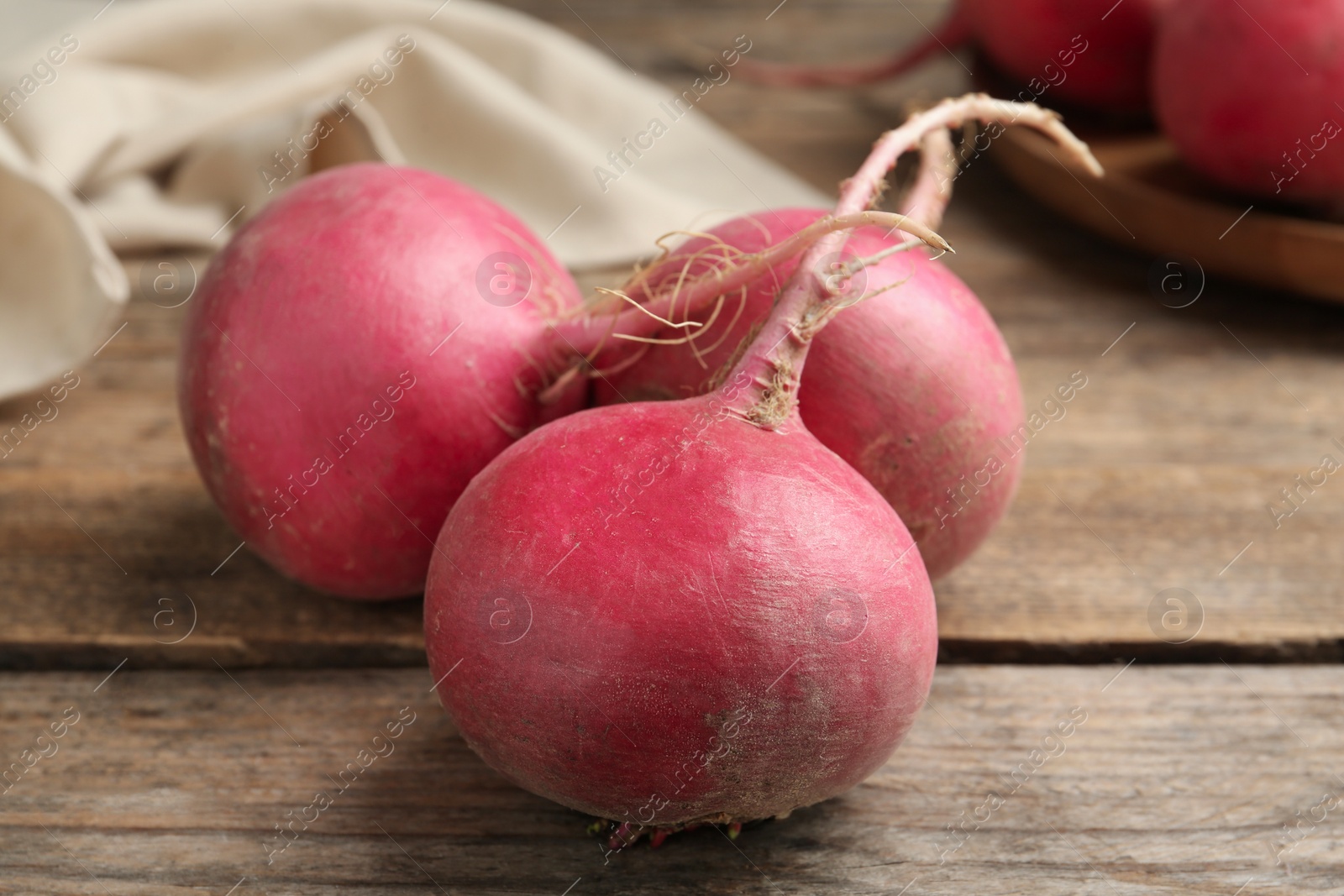 Photo of Ripe red turnips on wooden table, closeup