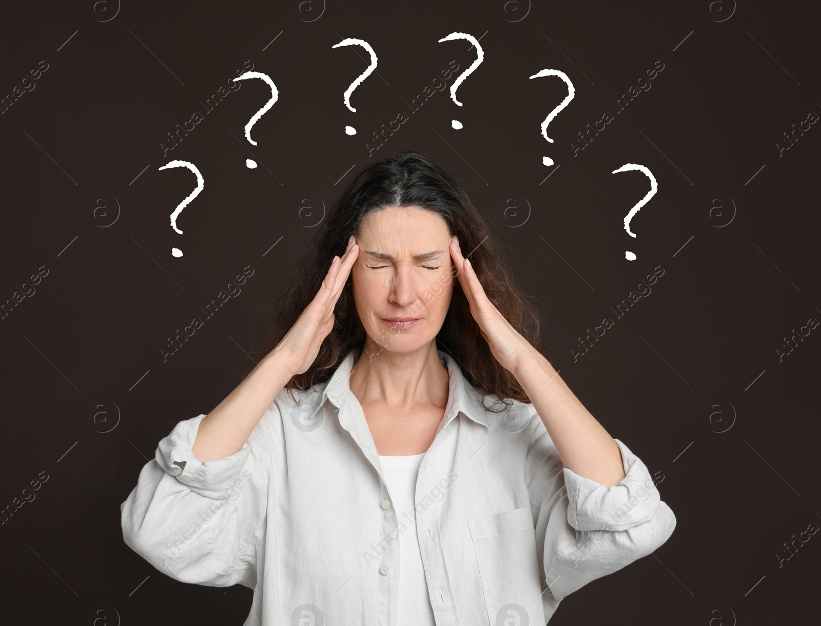 Image of Amnesia. Confused woman and question marks on brown background