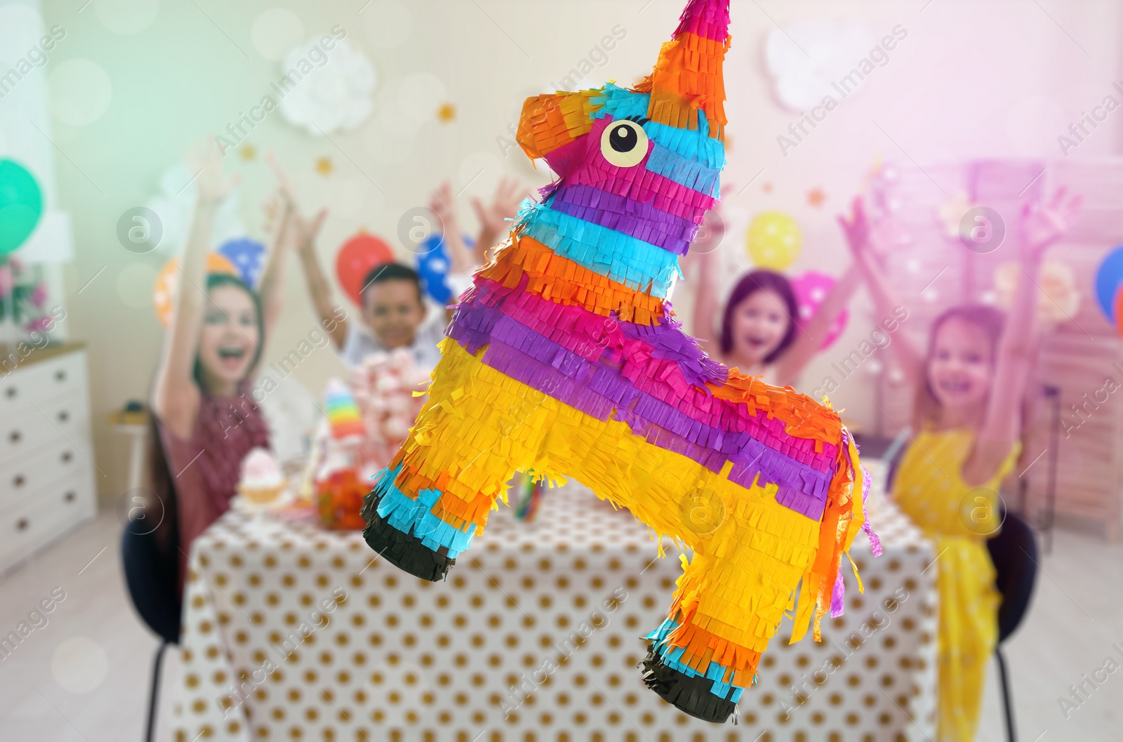 Image of Bright festive pinata hanging indoors at birthday party