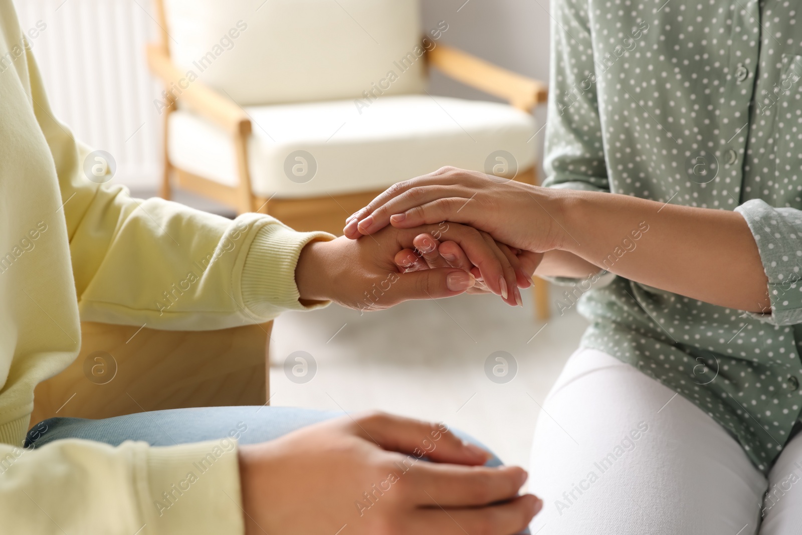 Photo of Psychotherapist holding patient's hand in office, closeup