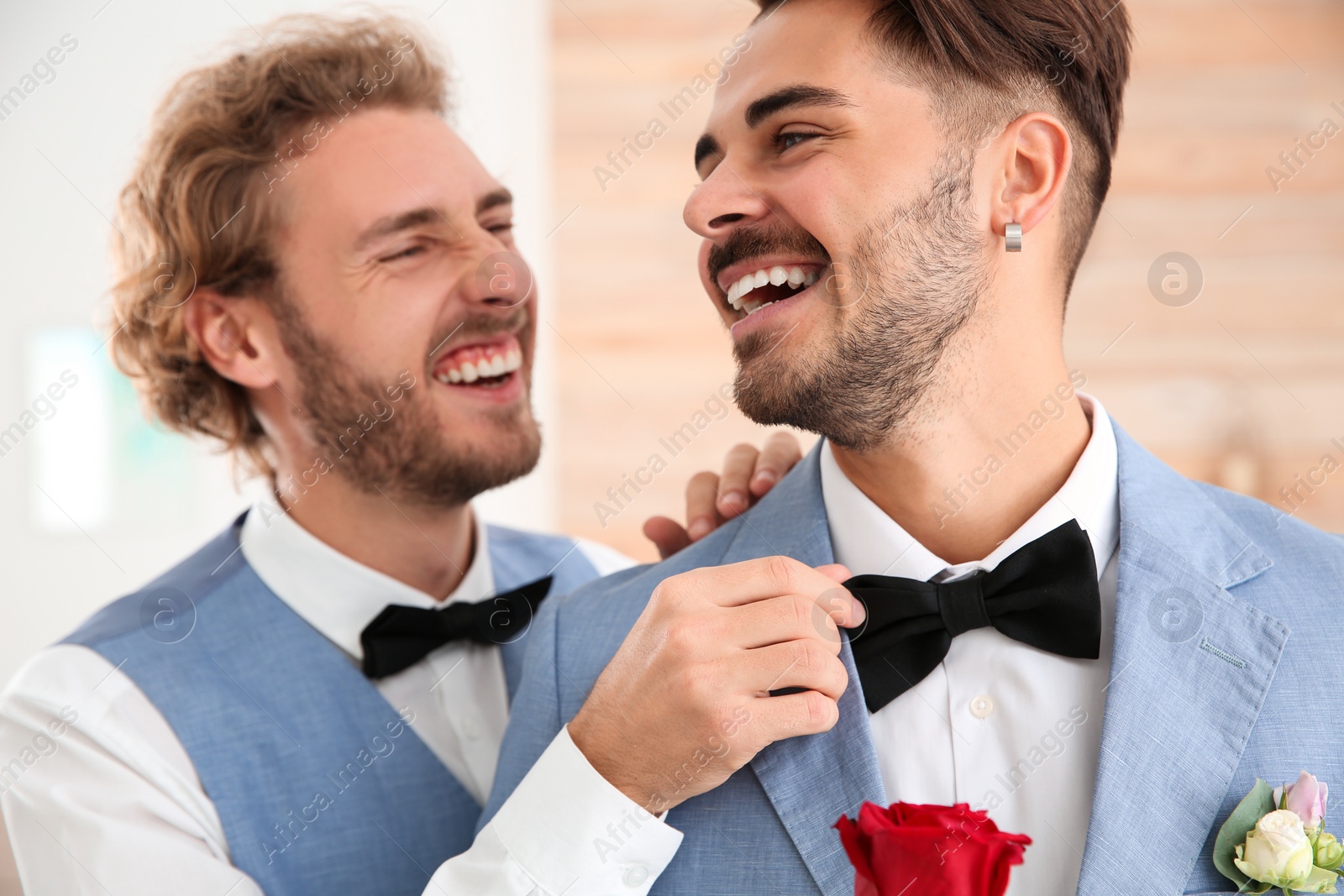 Photo of Happy newlywed gay couple with flower at home