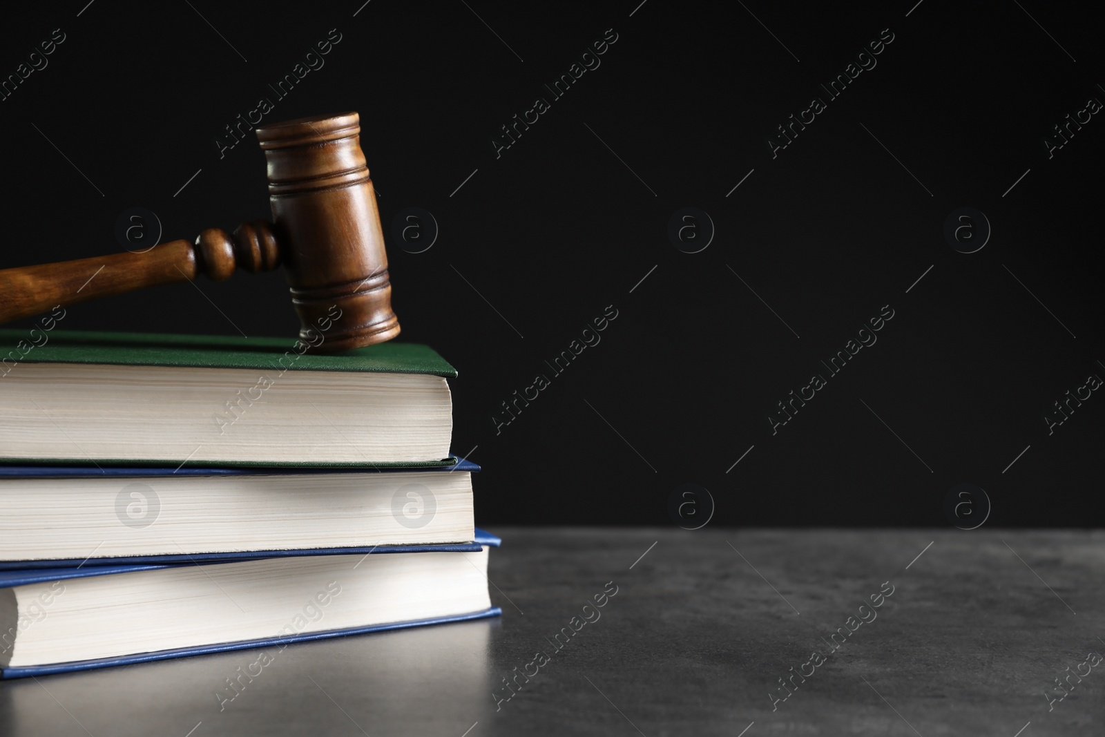 Photo of Judge's gavel and stack of books on table. Law concept