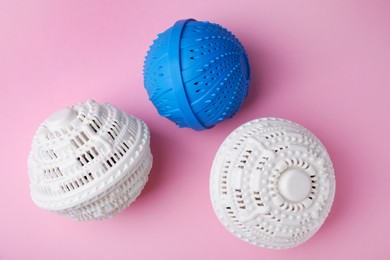 Photo of Dryer balls for washing machine on pink background, flat lay