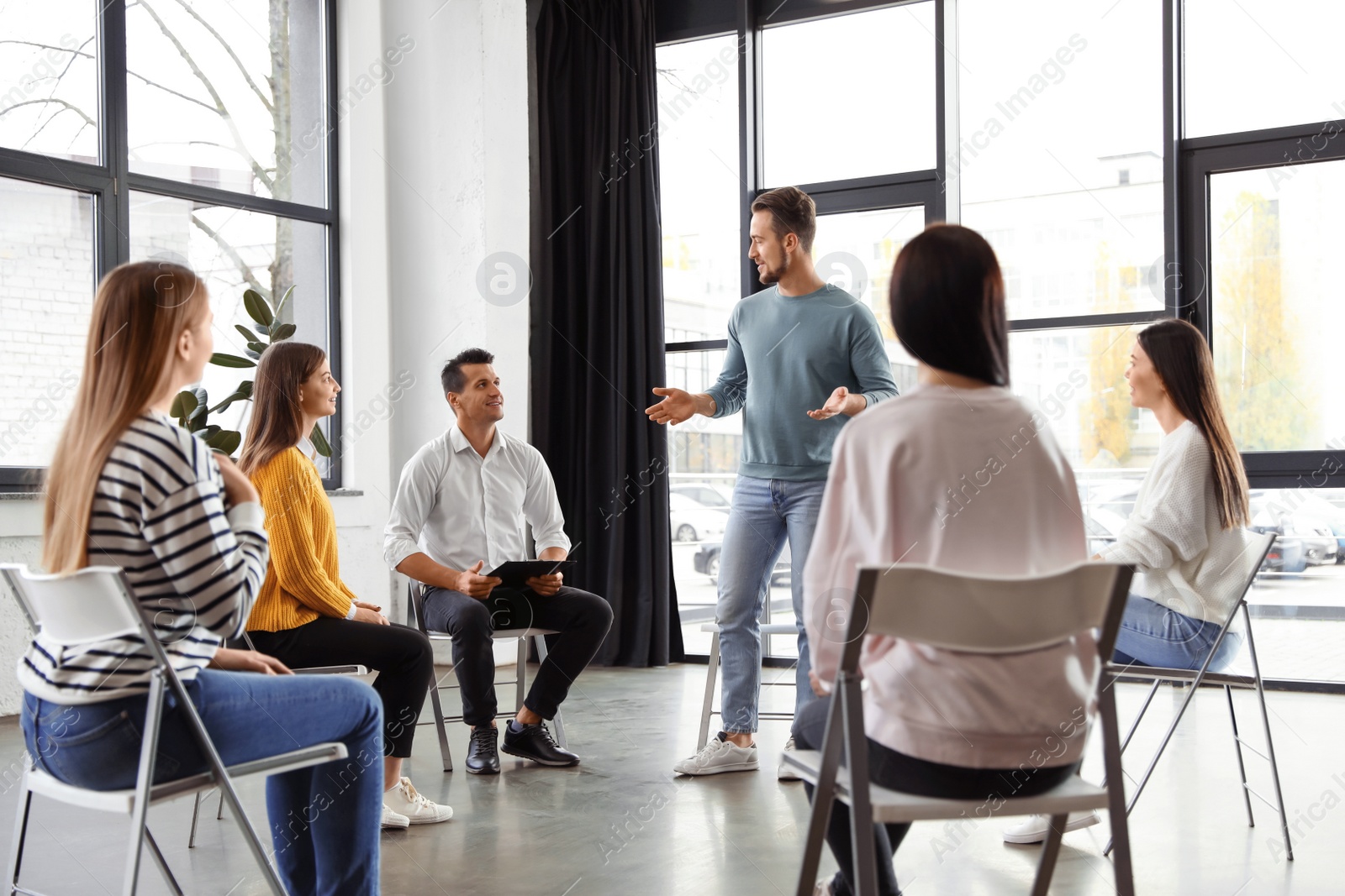 Photo of Psychotherapist working with patients in group therapy session indoors