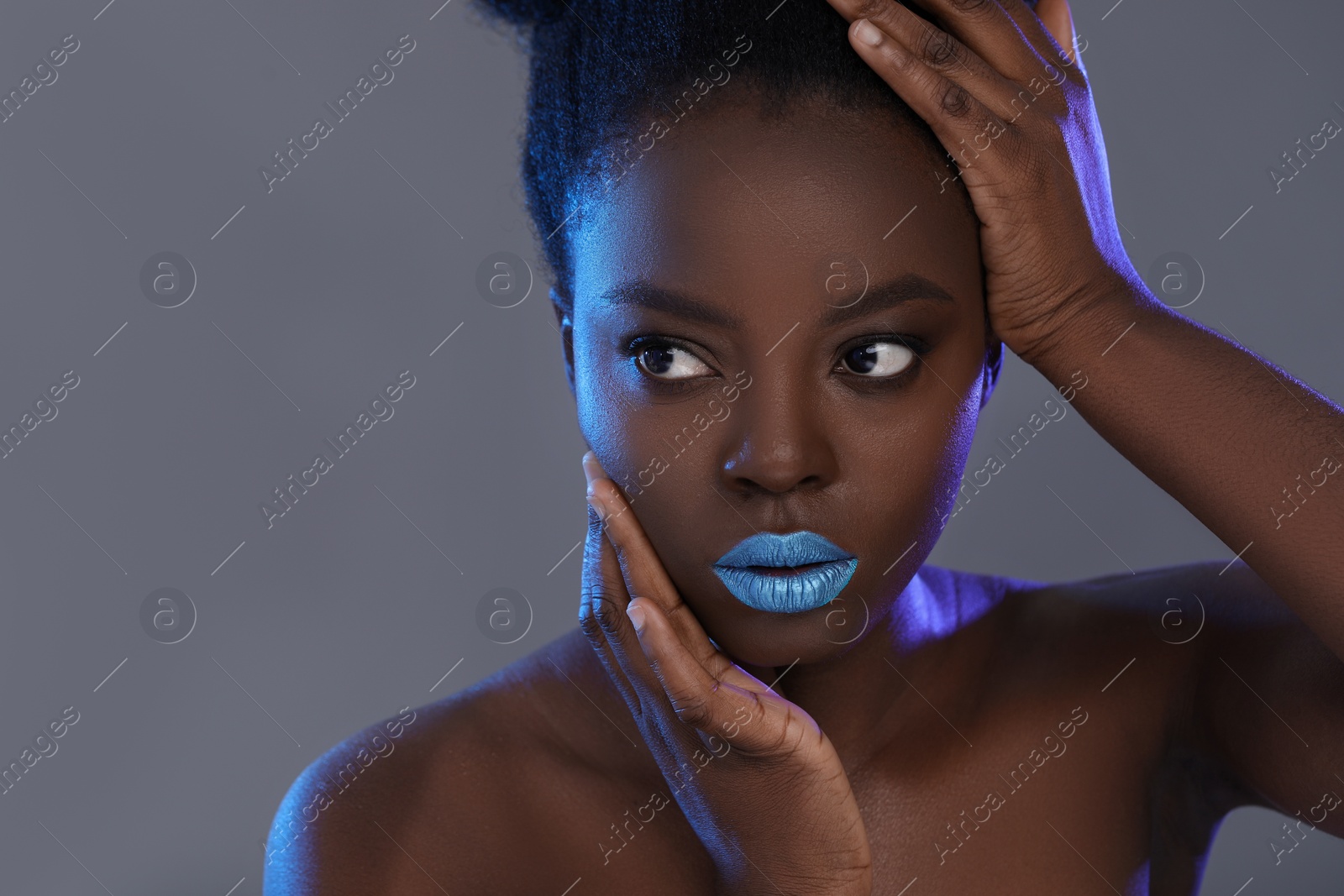 Photo of Fashionable portrait of beautiful woman with bright makeup on grey background, space for text