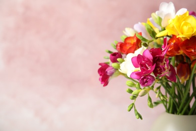 Photo of Bouquet of beautiful spring freesia flowers in vase on color background, space for text