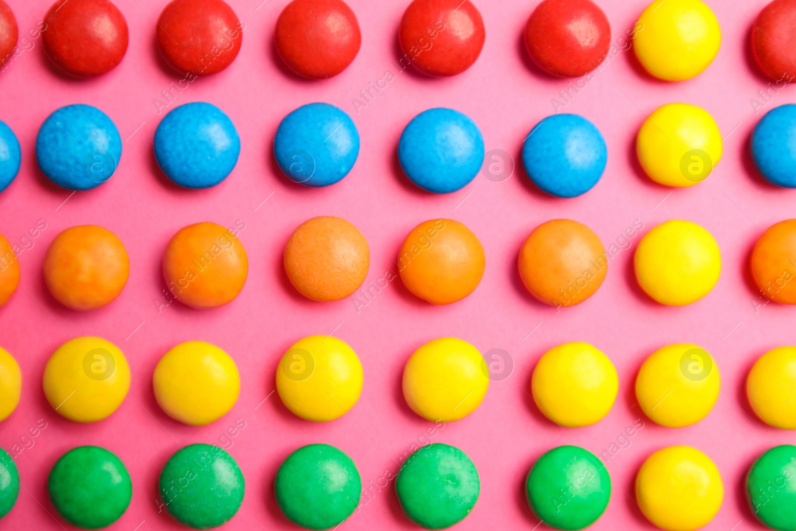 Photo of Tasty glazed candies on color background, top view