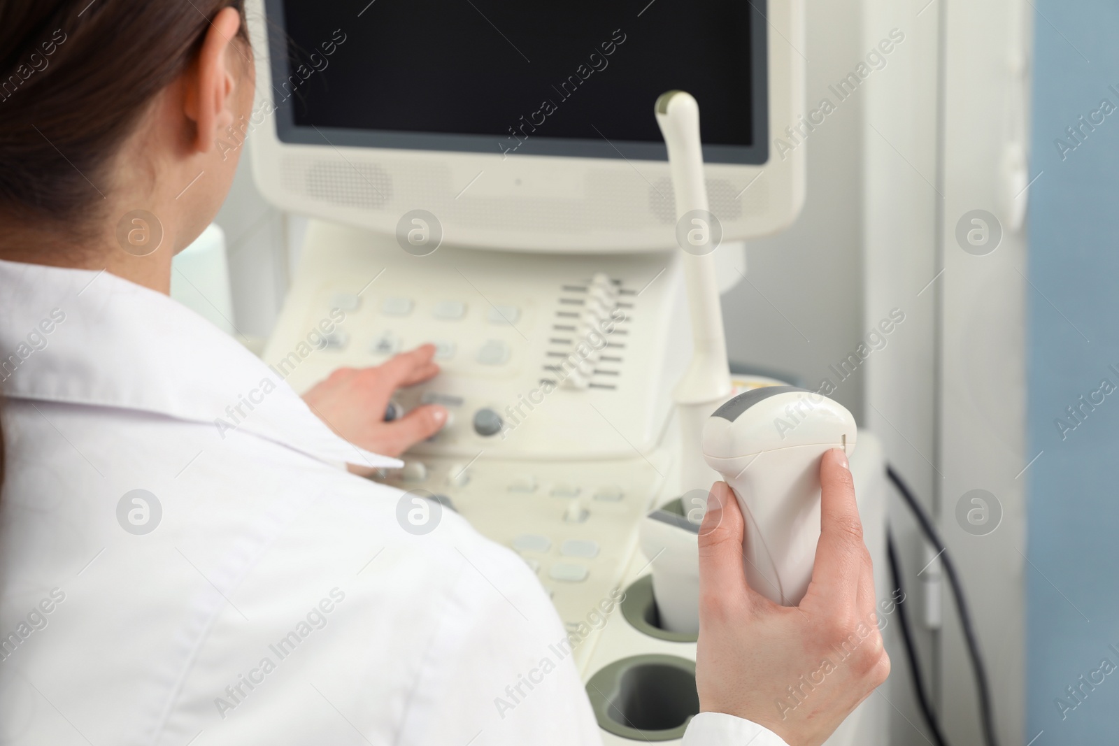 Photo of Professional sonographer using modern ultrasound machine in clinic, closeup